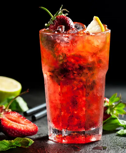 Refreshing strawberry mojito cocktail with ice, lemon slice, and fresh mint leaves on a dark background.